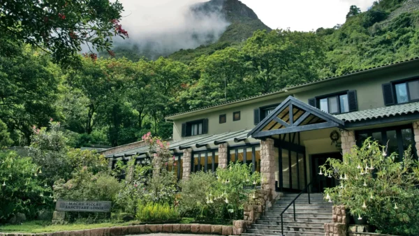 Belmond Sanctuary Lodge, hotel de lujo en la entrada de Machu Picchu, rodeado de montañas verdes y bosque nuboso.