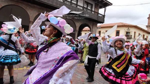 Carnaval en Perú con bailarines en vestimenta tradicional agitando pañuelos blancos en una plaza colonial, con sombreros festivos decorados con globos