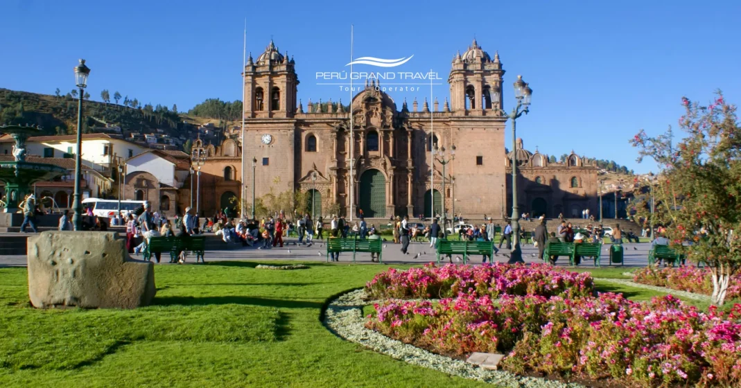 Catedral del Cusco frente a la Plaza de Armas, rodeada de jardines y actividad local, símbolo del legado colonial y la historia andina del Perú