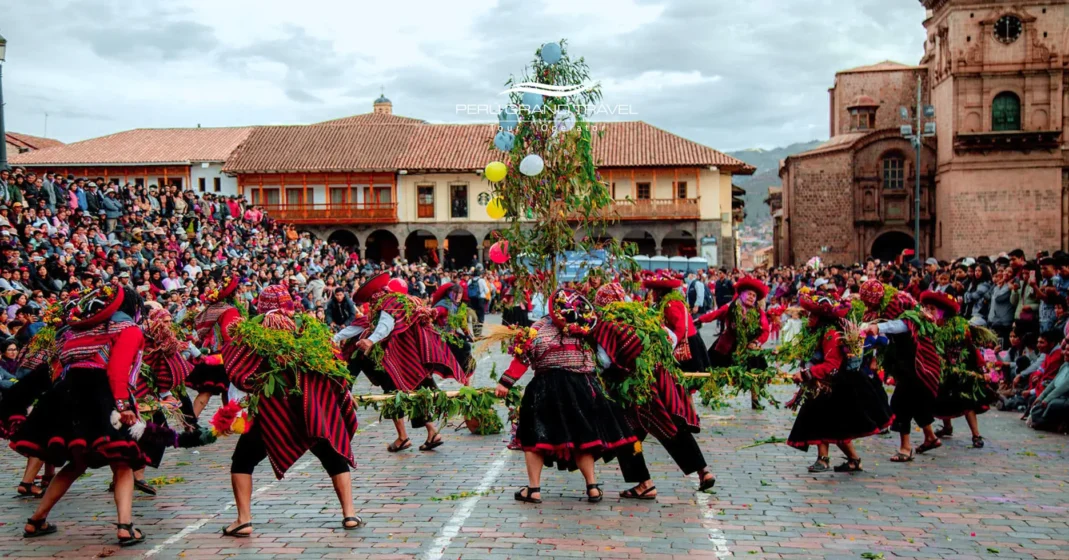 Ceremonia de la Yunza durante el Carnaval de Cusco, con danzantes de comparsa girando alrededor del árbol en la plaza principal, rodeados de una multitud festiva.