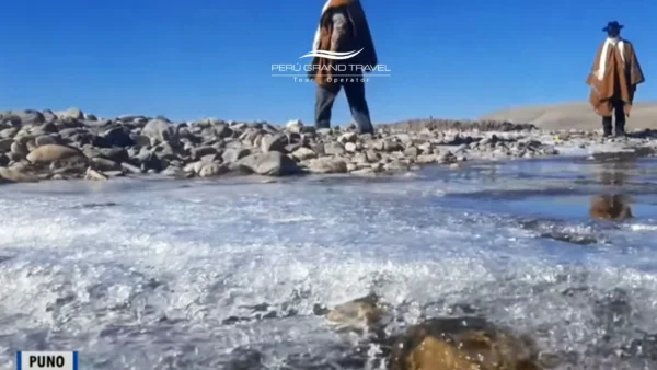 Clima en Puno con agua parcialmente congelada en la orilla, reflejando las bajas temperaturas de gran altitud cerca del lago Titicaca.