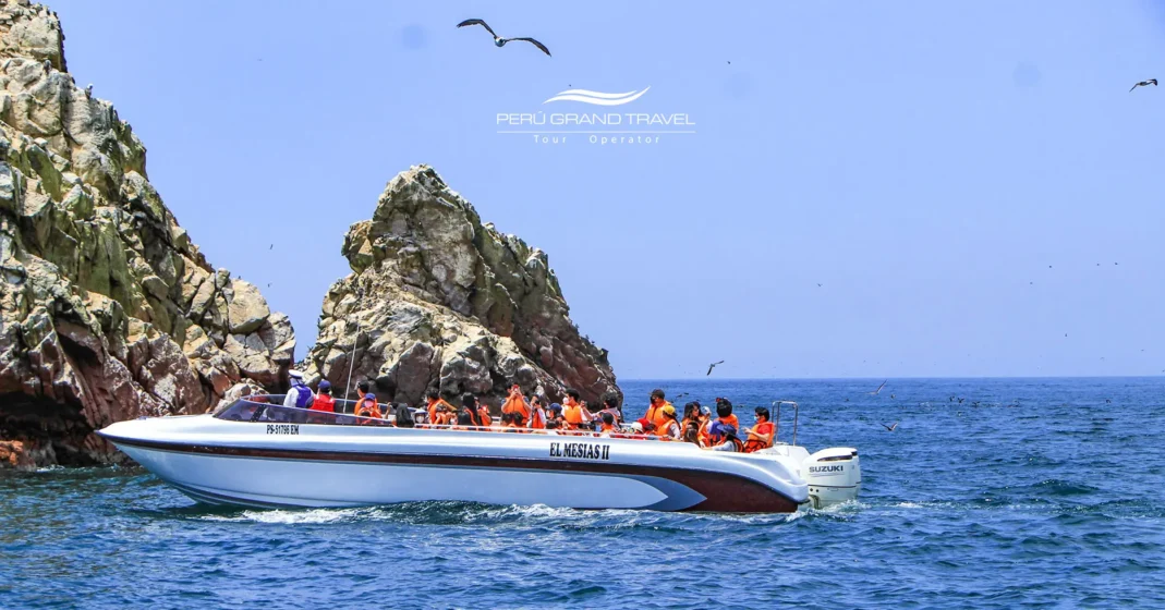 Litoral de Paracas no verão, com céu ensolarado, mar azul e calmo, e paisagens desérticas na Reserva Nacional de Paracas.