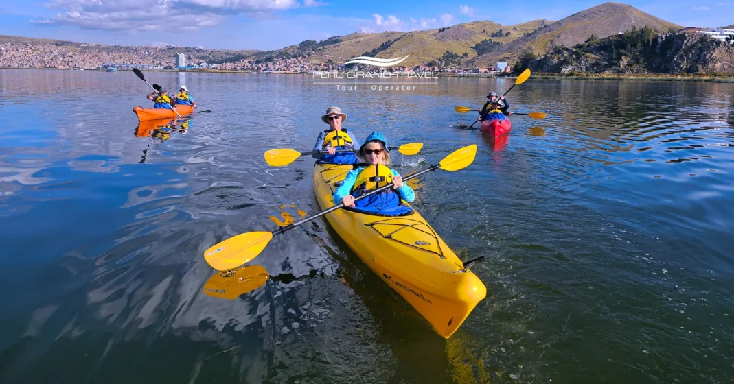 Turistas haciendo kayak o paddleboard en el Lago Titicaca con montañas andinas de fondo.