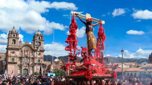Procesión del Señor de los Temblores en la Plaza de Armas de Cusco, con la imagen del Cristo crucificado cubierta de flores rojas de ñucchu y miles de fieles reunidos durante el Lunes Santo.