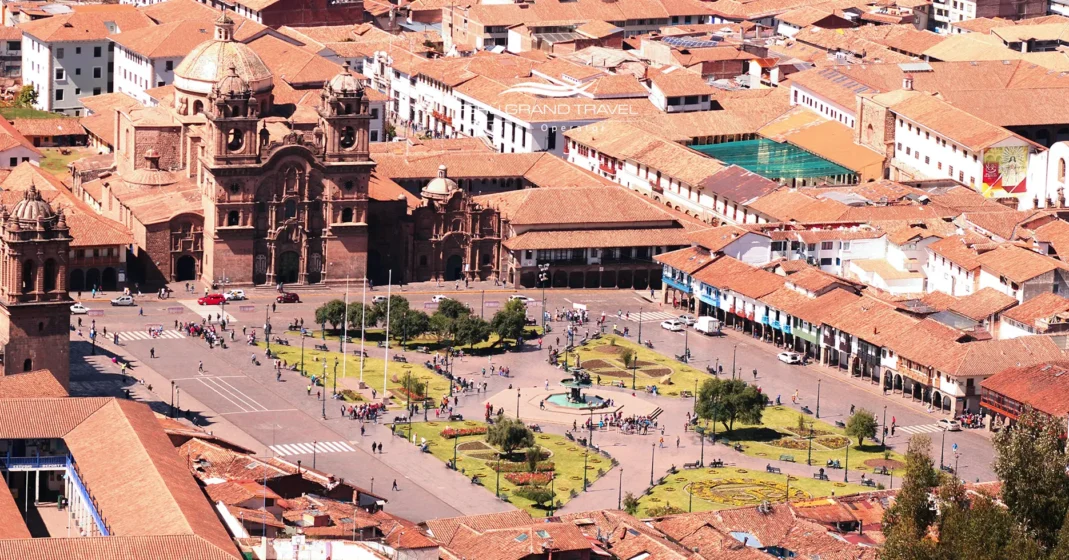 Plaza de Armas del Cusco bajo un cielo despejado y luminoso, con montañas al fondo y luz intensa del sol andino. La escena refleja la temporada seca, caracterizada por días soleados, aire fresco y un ambiente perfecto para recorrer la ciudad y disfrutar de su arquitectura colonial.