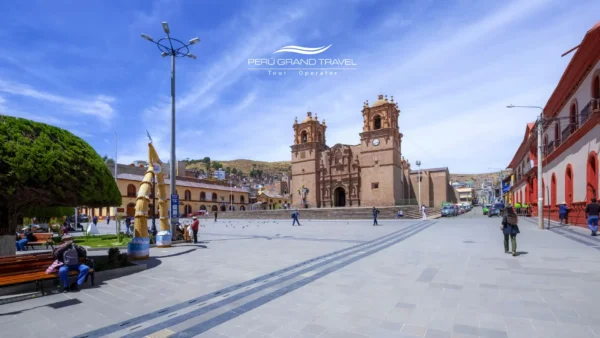 Vista amplia de la Plaza de Armas de Puno, con la catedral al fondo, edificios coloniales y un espacio peatonal abierto.