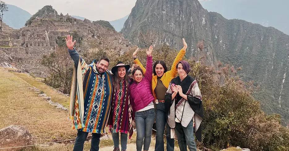 Amigos posando para la foto de fondo, la montaña de Machu Picchu y los espacios arqueológicos de fondo