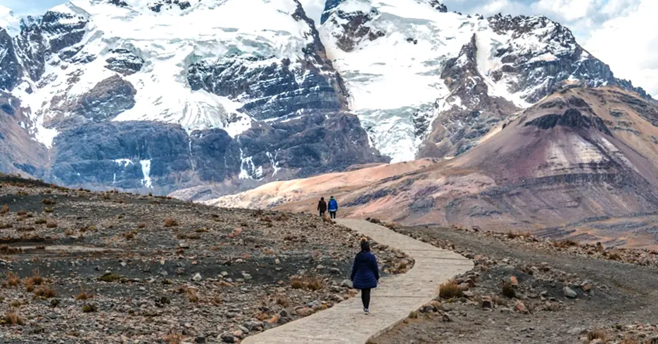 Huaraz Perú Tours para Todos los Gustos: Senderismo, Cultura y Paisajes de Ensueño 7 Camino para el nevado de pastoruri, se observa una montaña con nieve y un camino asfaltado para que sea más fácil la caminata
