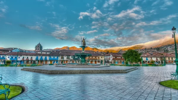 Plaza de armas el centro principal, con vistas de balcones y un cielo celeste despejado y la estatua inca en el medio de la plaza