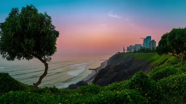 Lima en un atardecer con la vista del malecón de Miraflores, la vista del océano pacífico y mucha vegetación verde
