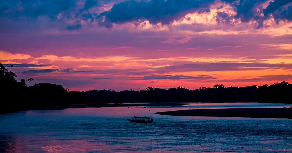 vista del atardecer en la selva peruana con vista de bote y lago sandoval