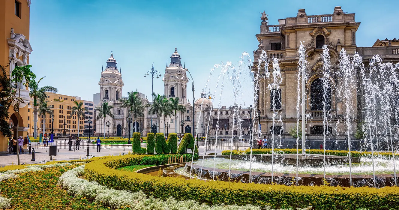 centro historico de lima, con la vista de la catedral al fondo, una fuente y varios edificios