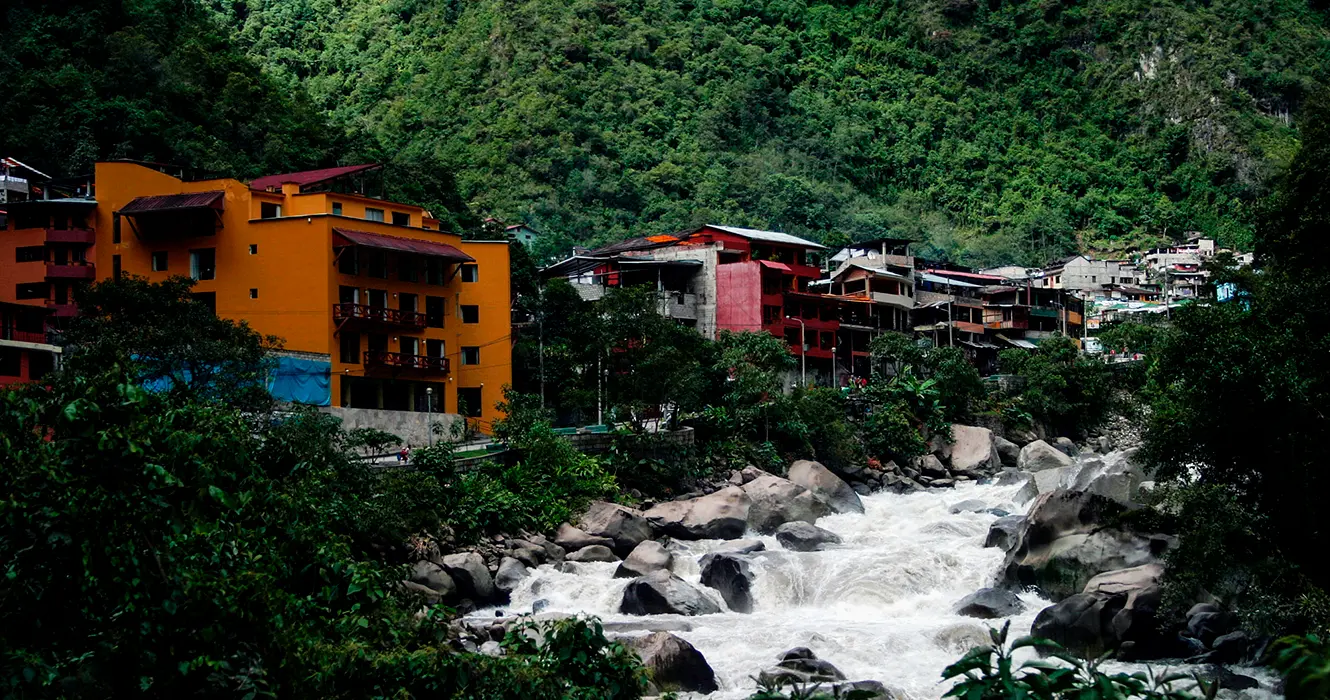 machu picchu pueblo o tambien llamado aguas calientes, rodeado de grandes montañas, el rio urubamba y mucha vegetacion