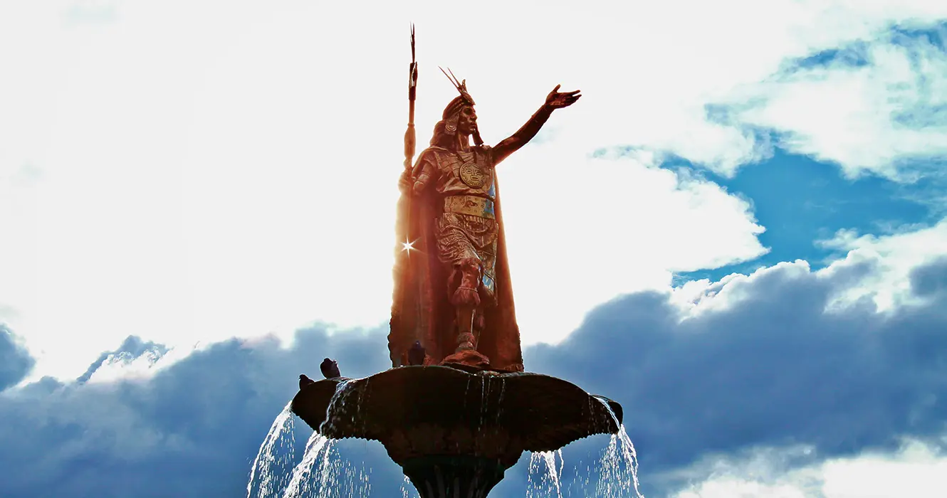 Viaja sin estrés: los mejores paquetes turísticos Cusco 4 La estatua del inca pachacuteq en la plaza de armas de cusco con un cielo celeste y varias nubes