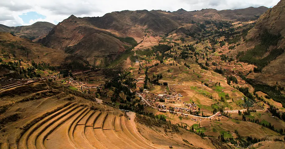 Centro arqueológico de pisac en el valle sagrado, se ve una vista de los andenes de este lugar y la vista que ofrece, llena de montañas y árboles con espacios verdes y marrones