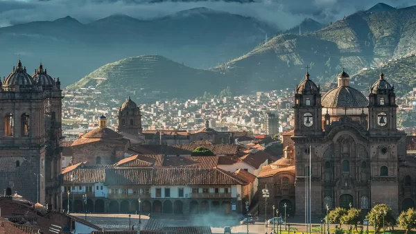 La ciudad de cusco, en que lugares puedo visitar en Perú, vista de la catedral y la iglesia de la compañía de Jesús, y atrás las casas y edificios de cusco