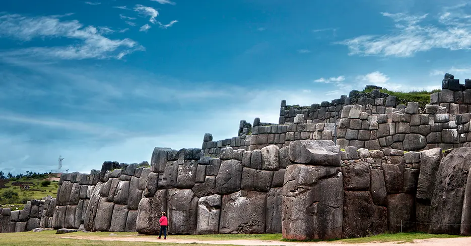 sacsayhuaman en el City tour de cusco varias piedras grandes y un cielo celeste despejado
