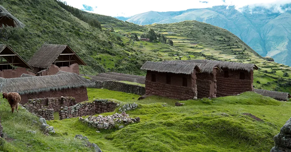 Centro arqueológico de Huchuy Qosqo uno de los lugares turisticos a visitar en cusco Perú, con una vista del valle sagrado color verde y lleno de vegetación y rodeado de montañas