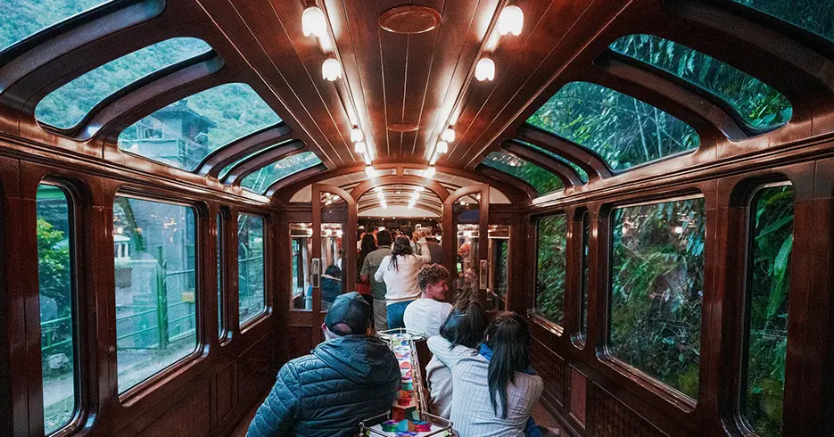 Tren vistadome rumbo a cusco, turistas celebrando y algunos sentados