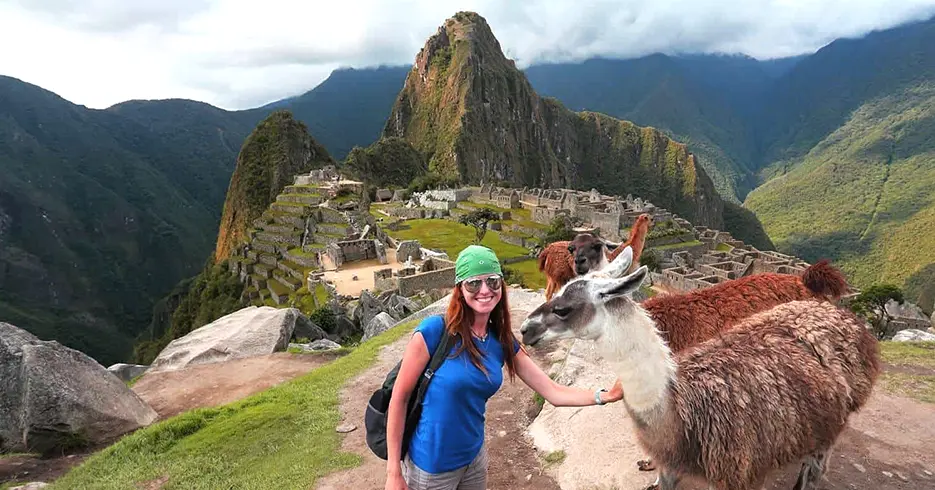 Descubre Cusco en 7 Días: La Mejor Ruta con Picnic en la Tierra de los Incas 8 Turista posando con llamas con la vista de machu picchu al fondo