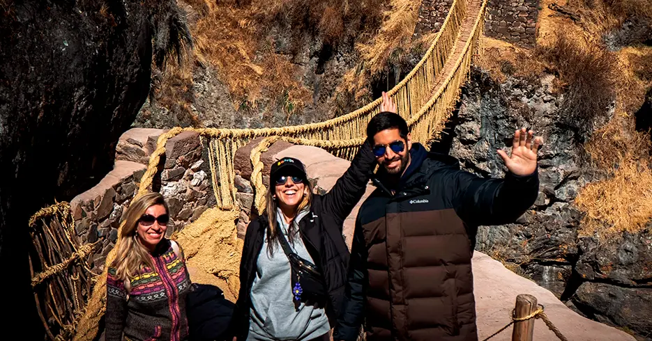 Explora Qeswachaka: el puente inca que se renueva cada año 4 turistas en el puente qeswachaka sonriendo y disfrutando