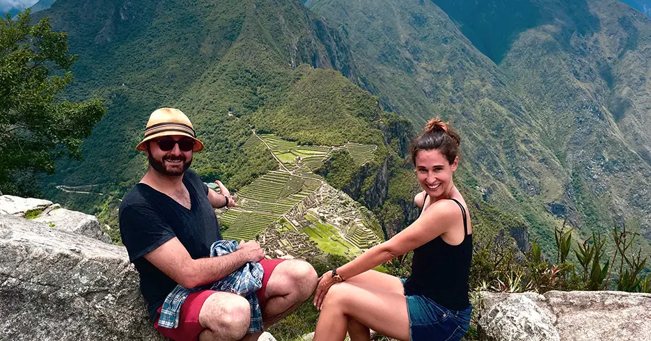 Turistas en la punta de huayna picchu y mostrando la ciudadela inca en la parte baja se encuentran en el valle sagrado y Machu Picchu