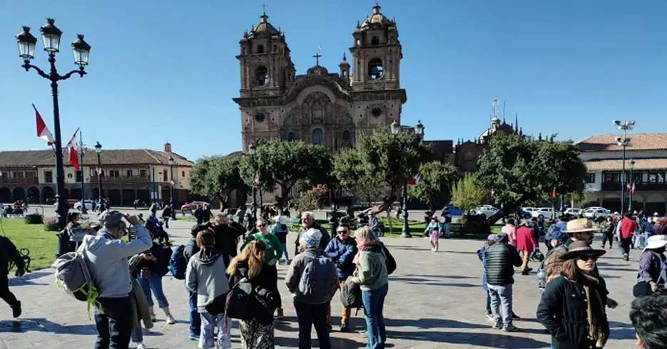 Muchos turistas en la plaza principal de cusco con la vista de la iglesia de la compañía de Jesús