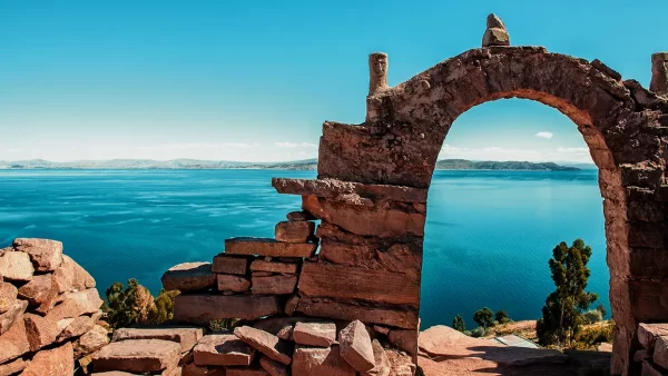Arco rocoso de la isla taquile en puno con una vista amplia del lago Titicaca y un cielo turquesa parecido al lago Titicaca