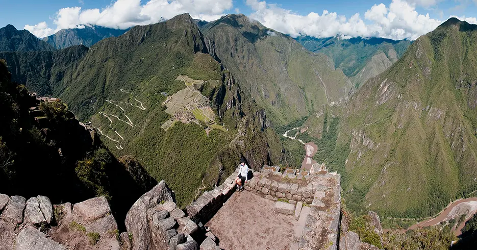 Machu Picchu En Un Día: Ruta Rápida para No Perderte lo Mejor 4 Turista posando en una de las vistas de huayna picchu, en la parte baja se observa la ciudadela inca, y el río urubamba